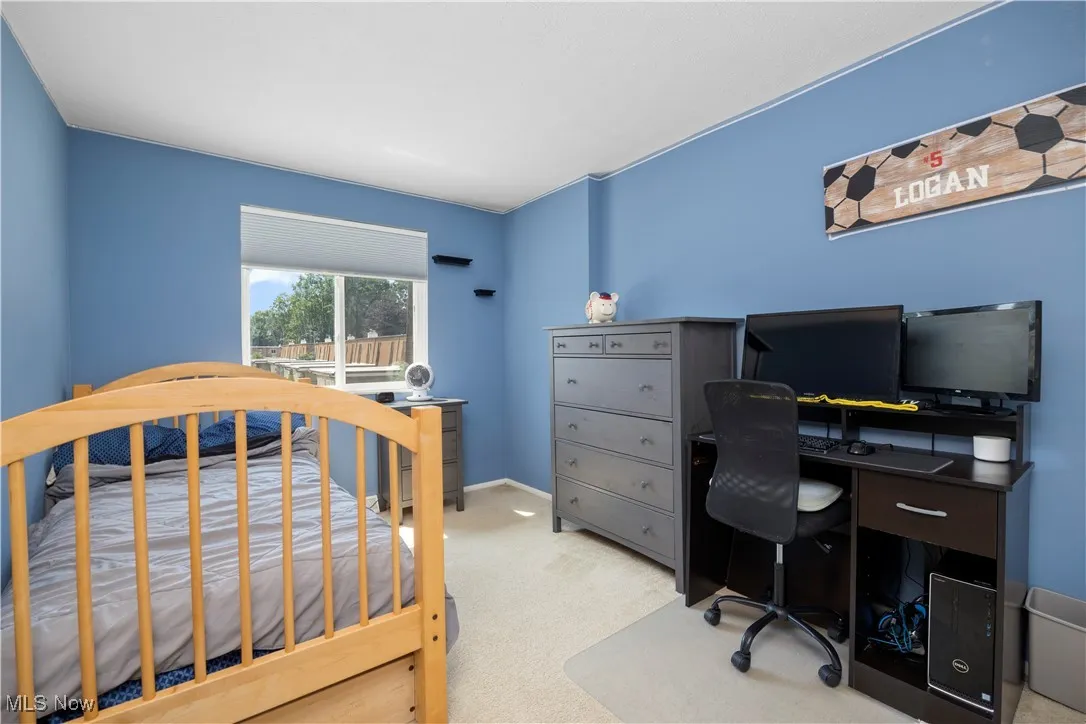 Carpeted bedroom with a desk
