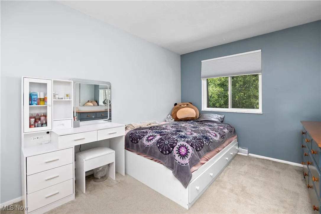 Bedroom featuring light colored carpet and baseboards