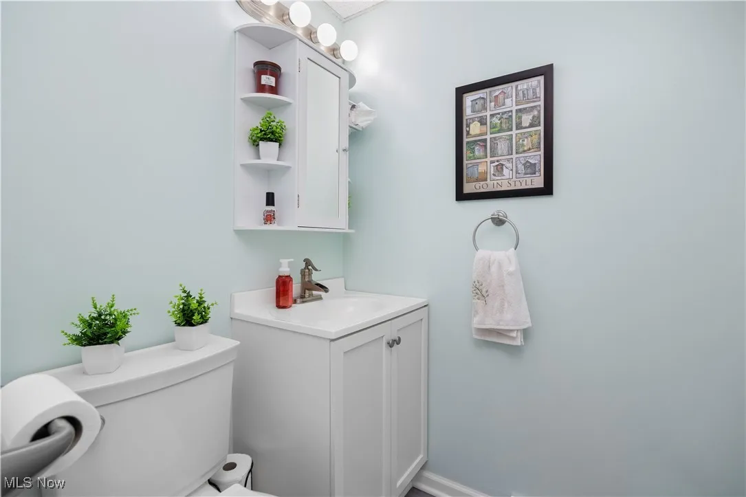 Half bathroom featuring vanity and toilet