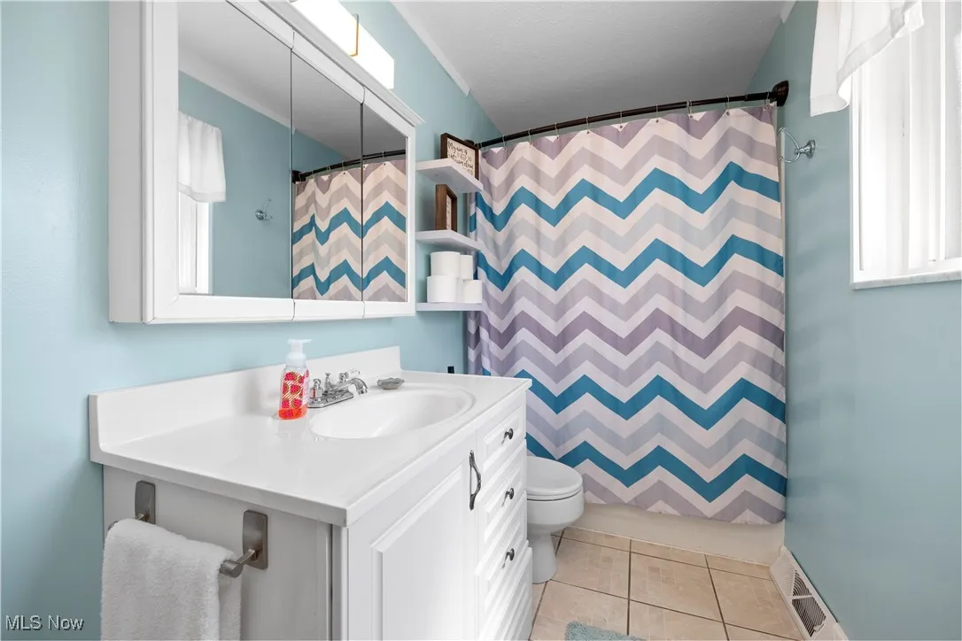 Bathroom featuring vanity, tile patterned floors, and a shower with curtain