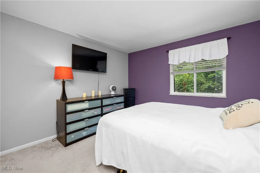 Bedroom featuring baseboards and light carpet