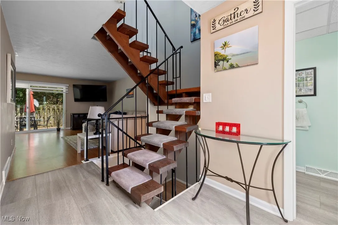 Stairs featuring wood finished floors and baseboards