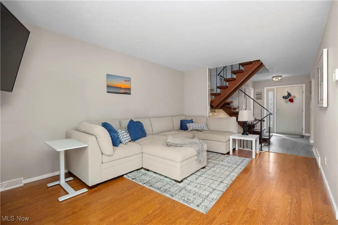 Living area featuring stairs and wood finished floors