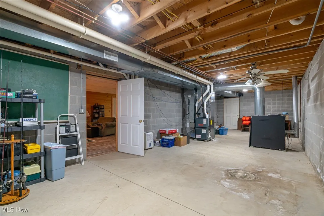 Unfinished below grade area with concrete block wall and heating unit
