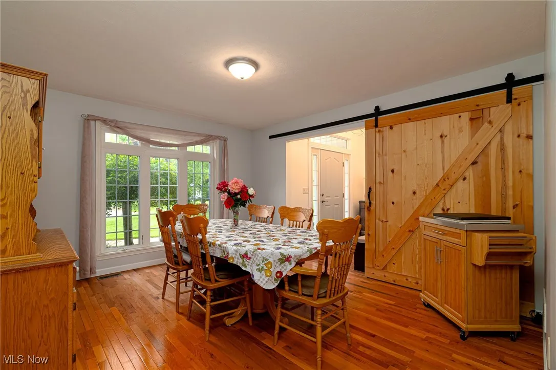 Dining room featuring light wood finished floors and a barn door
