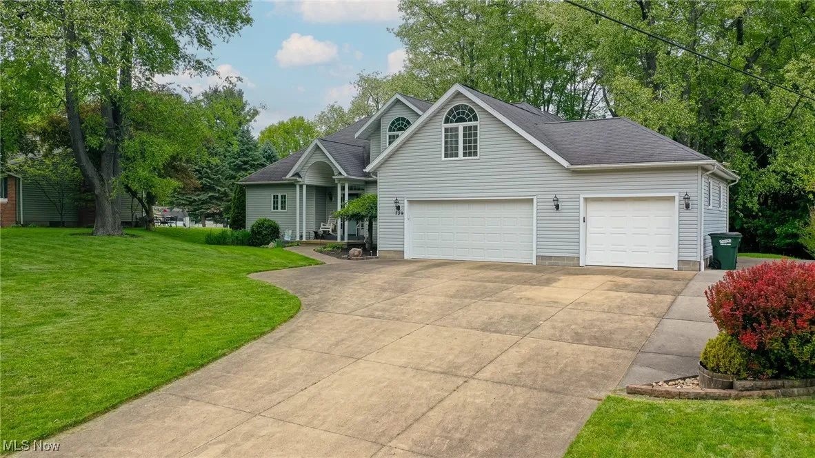 Traditional home featuring concrete driveway, a front lawn, and a garage