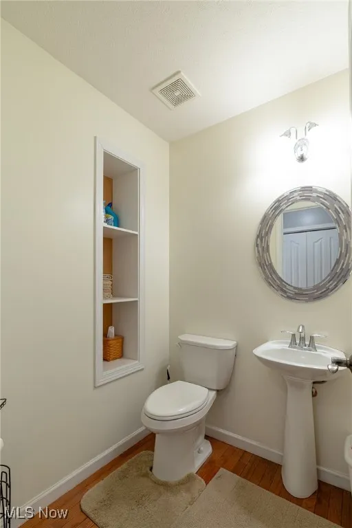 Bathroom featuring toilet and wood finished floors