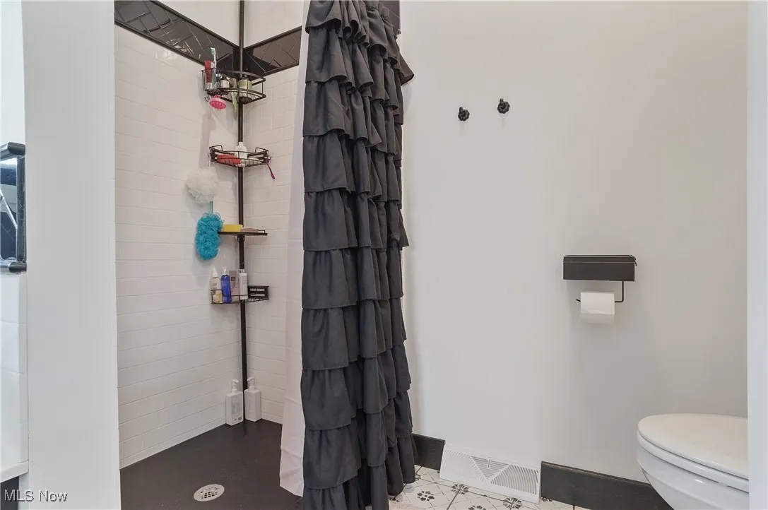 Full bathroom with toilet and a tile shower