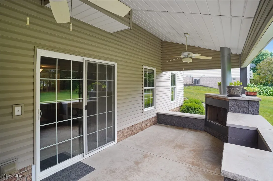 View of patio / terrace featuring ceiling fan and a fireplace