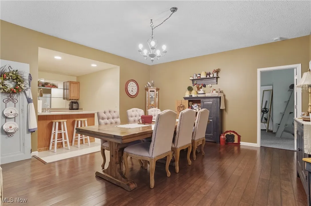 Dining room featuring a chandelier, dark wood-type flooring, and recessed lighting