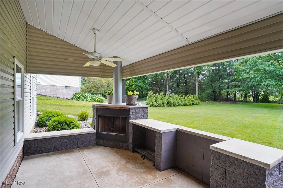 View of patio / terrace with a multi sided fireplace and ceiling fan