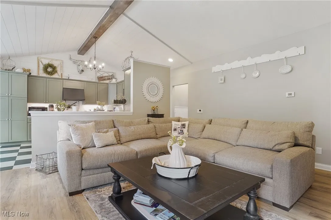 Living area featuring light wood-type flooring, a chandelier, and recessed lighting