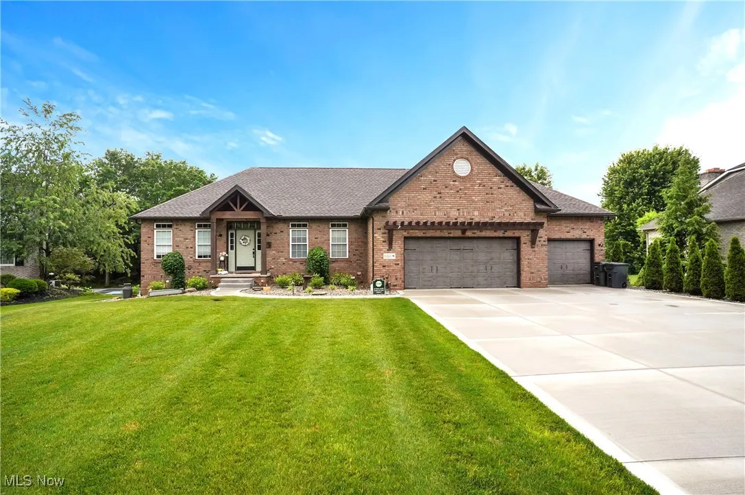 View of front of home featuring brick siding, an attached garage, and a front lawn