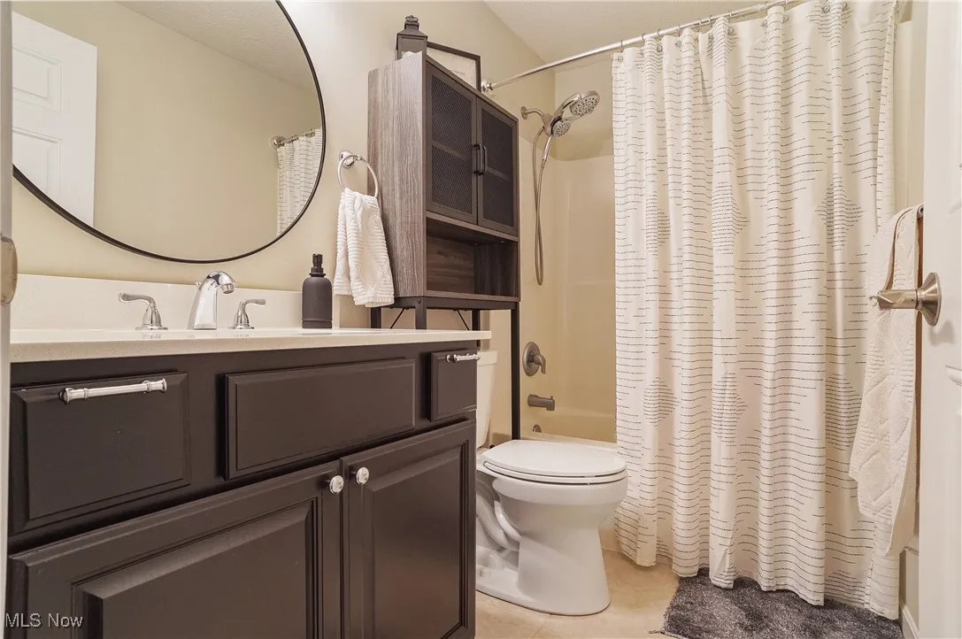 Full bath featuring vanity, tile patterned floors, and shower / bath combo