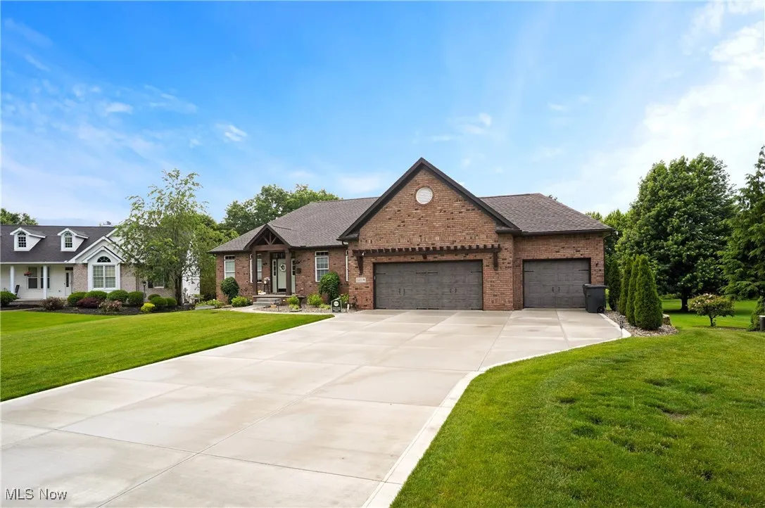View of front of home featuring brick siding, a garage, a front lawn, concrete driveway, and a shingled roof