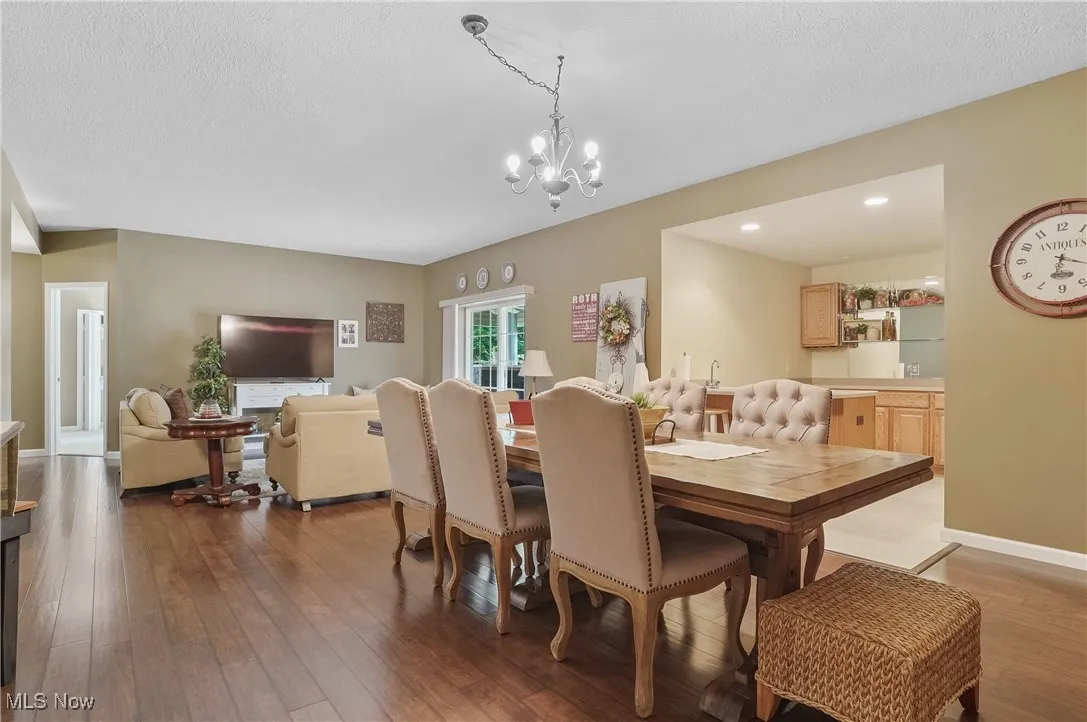 Dining space featuring wood-type flooring, a chandelier, a textured ceiling, and recessed lighting