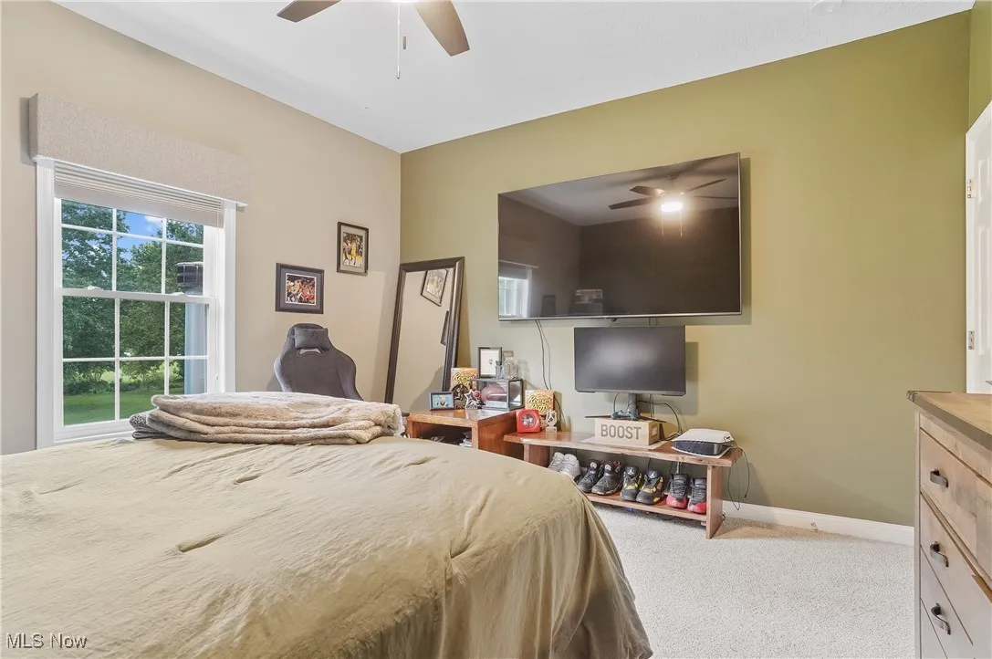 Carpeted bedroom with baseboards and a ceiling fan