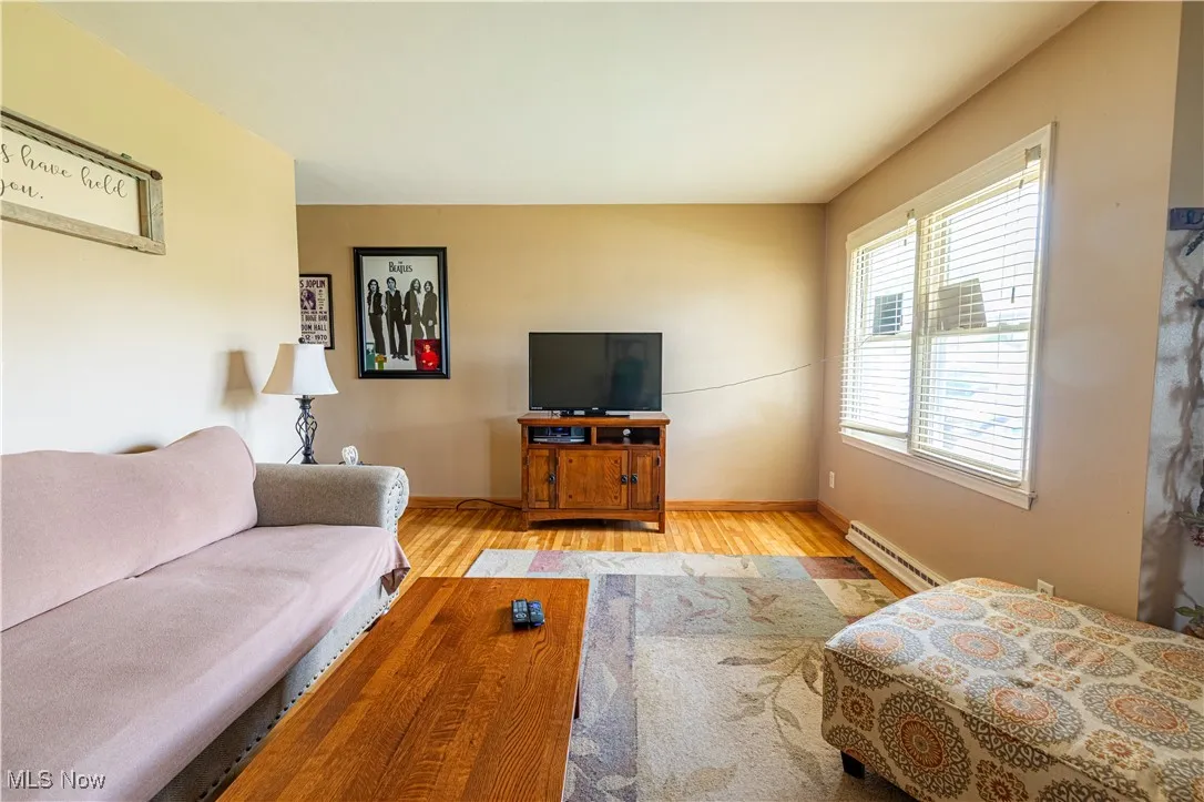 Living room featuring a baseboard radiator and wood finished floors