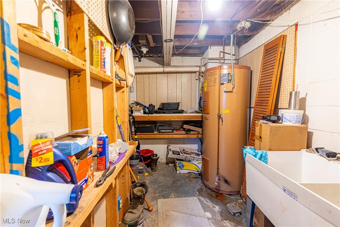 Unfinished basement with water heater and concrete block wall