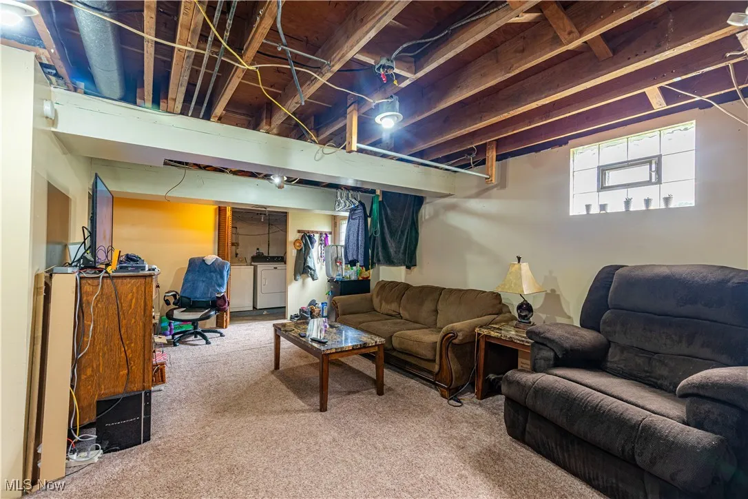 Living area featuring washing machine and clothes dryer and carpet flooring