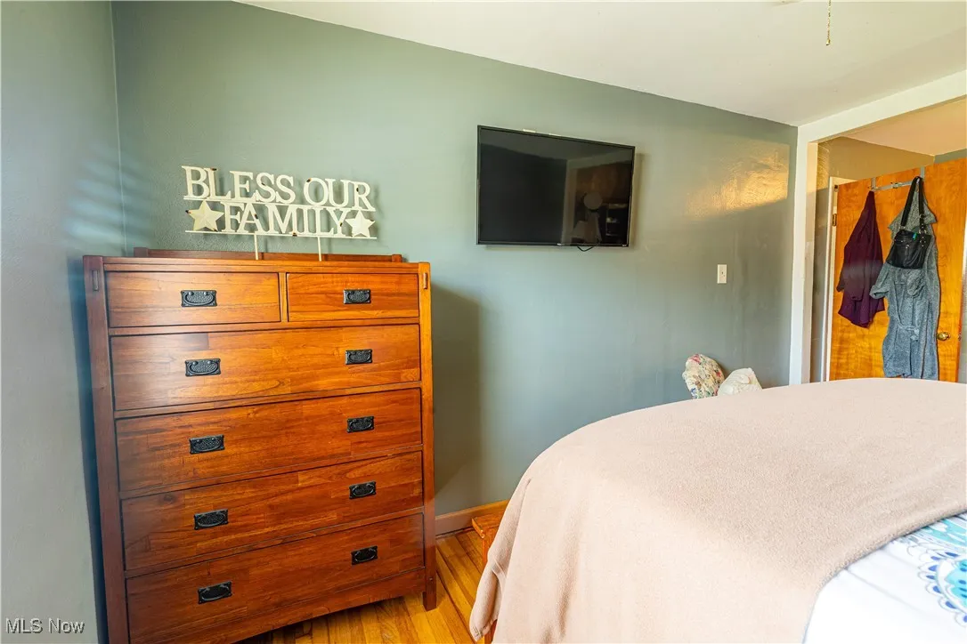 Bedroom with wood finished floors and baseboards