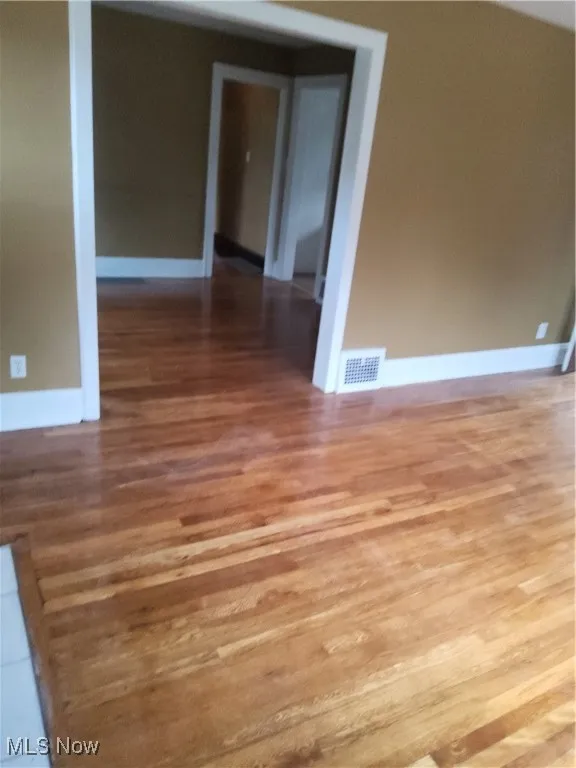 Unfurnished room with light wood finished floors and baseboards
