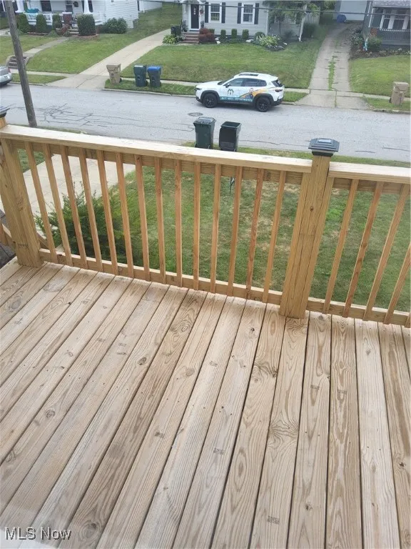 Wooden terrace featuring a yard