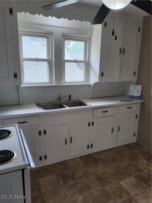 Kitchen with white cabinets, stone finish floors, and light countertops