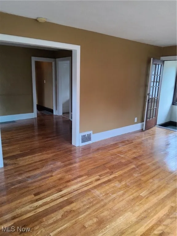 Empty room with wood finished floors and a smoke detector