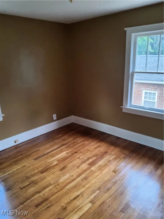 Spare room with wood finished floors and baseboards
