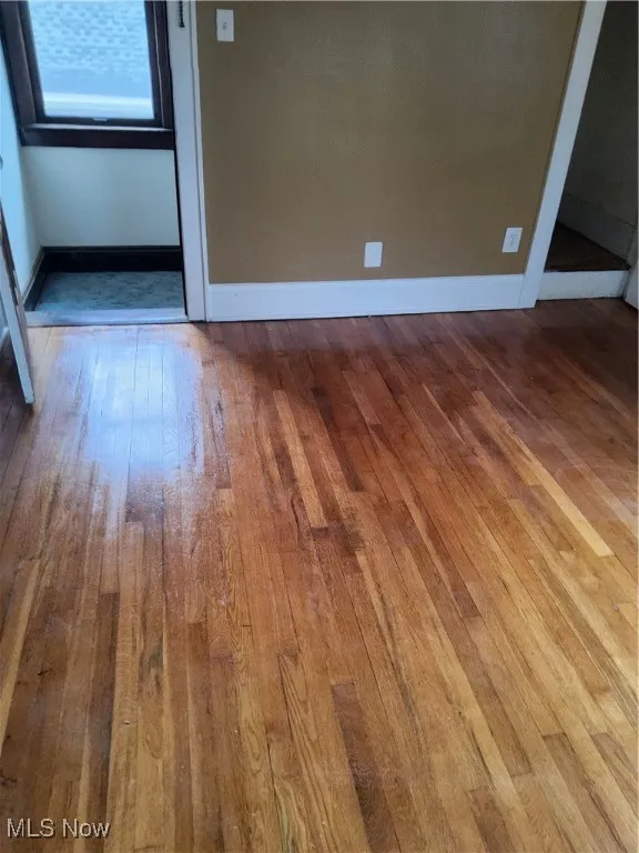 Spare room featuring hardwood / wood-style flooring and baseboards