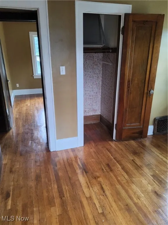 Unfurnished bedroom with hardwood / wood-style flooring and a closet