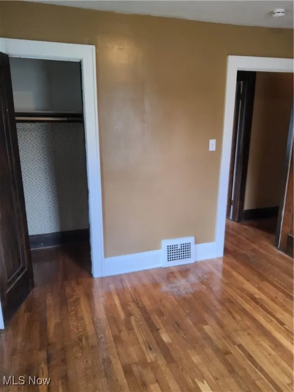 Unfurnished bedroom featuring wood finished floors and a closet