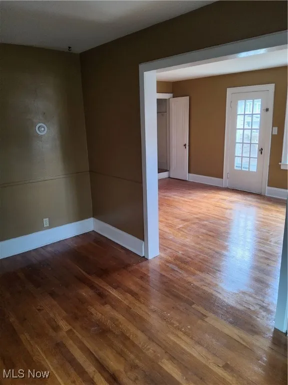 Unfurnished room with hardwood / wood-style floors and baseboards