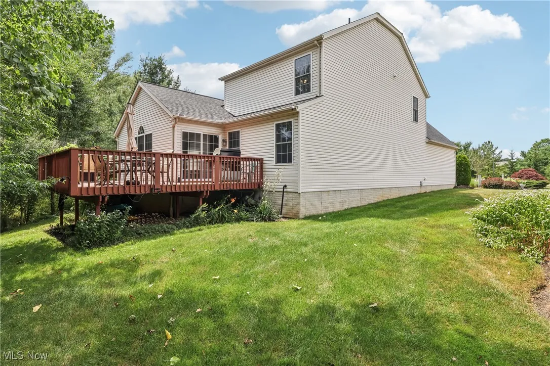 Back of house featuring a deck and a lawn
