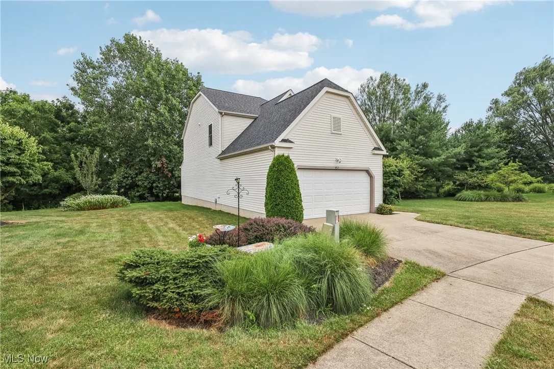 View of side of the property with landscaping and 2 car attached garage