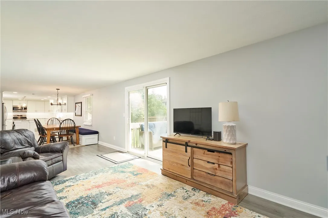 Living room with light wood-style flooring, a chandelier, and recessed lighting