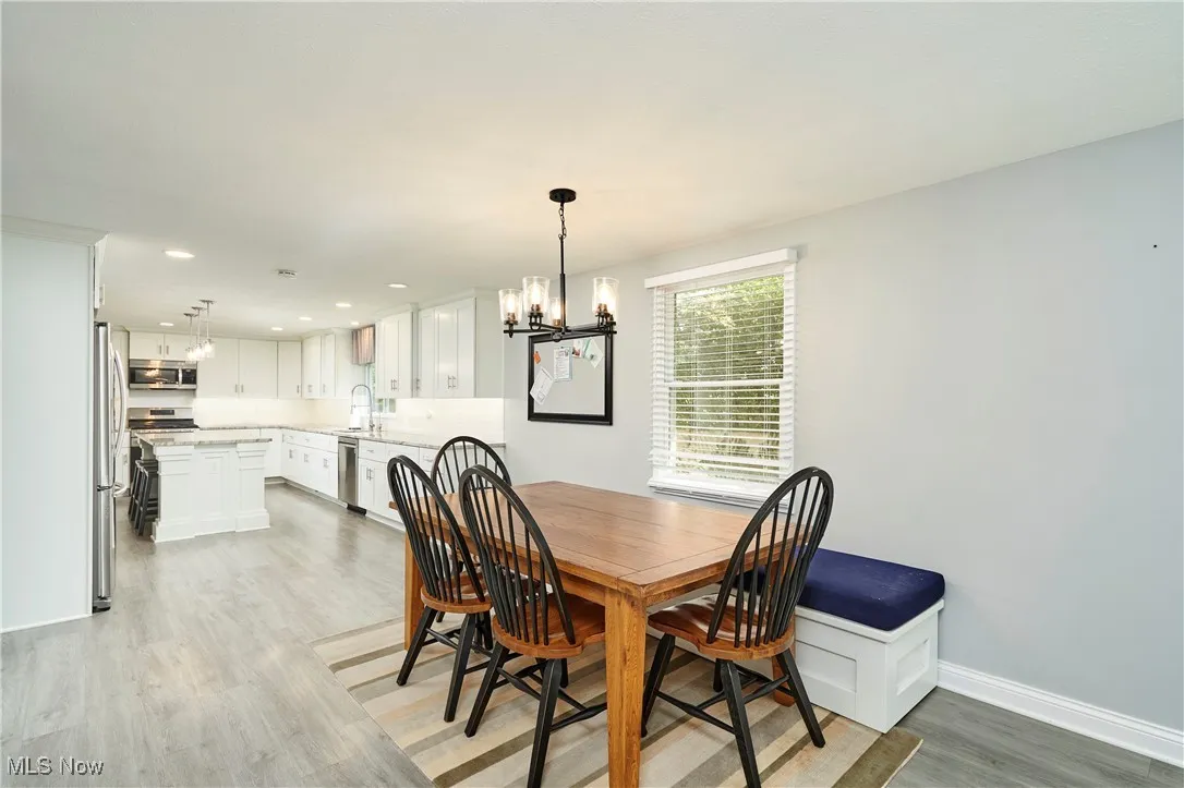 Dining space with light wood-style floors, a chandelier, and recessed lighting