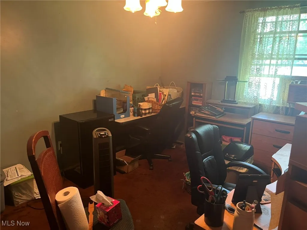 Office with a chandelier and carpet flooring