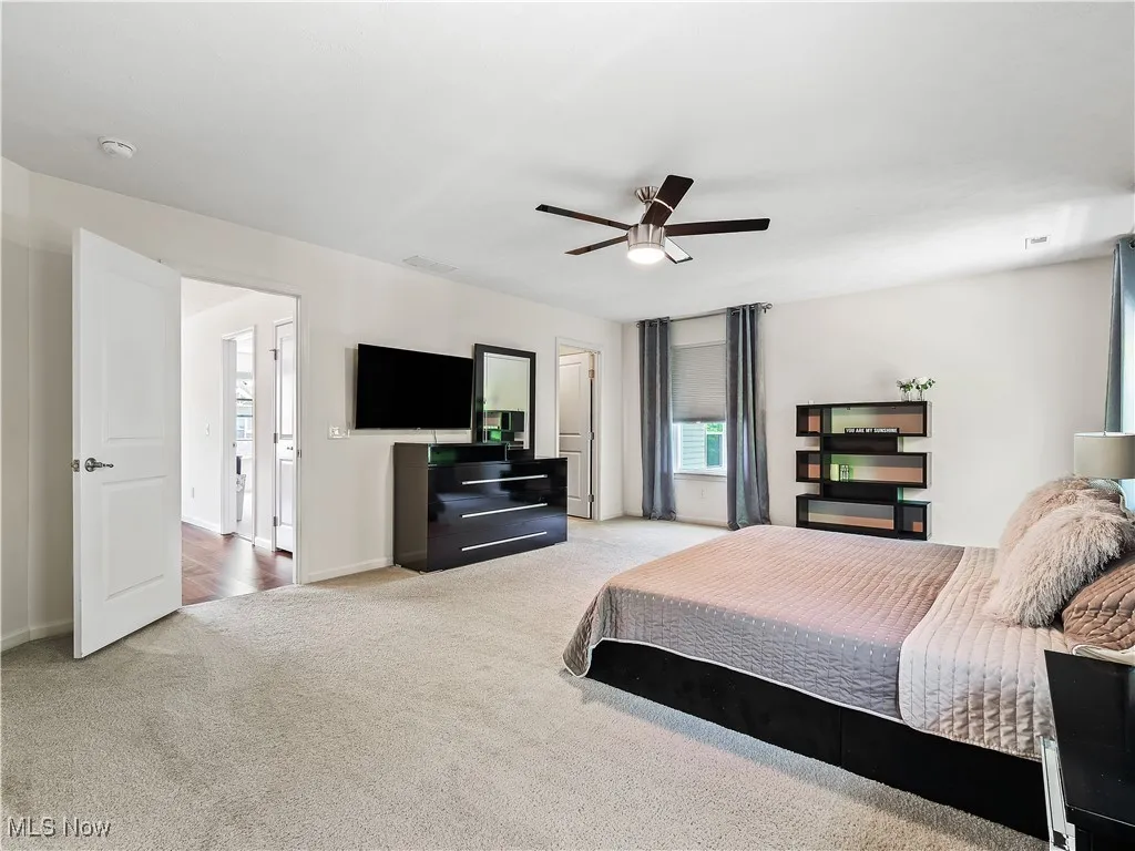 Carpeted bedroom with baseboards and ceiling fan
