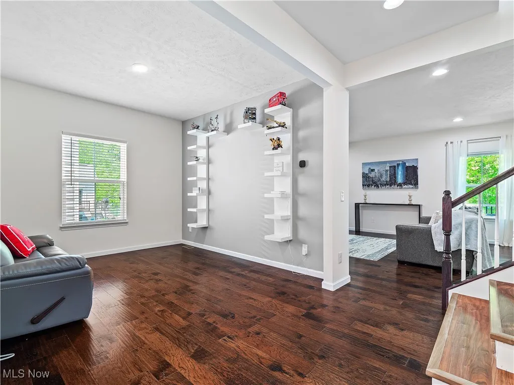 Living area with plenty of natural light, wood finished floors, and recessed lighting
