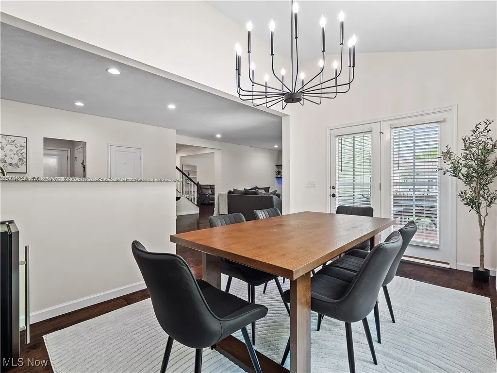 Dining room featuring stairway, dark wood-style floors, a chandelier, and recessed lighting