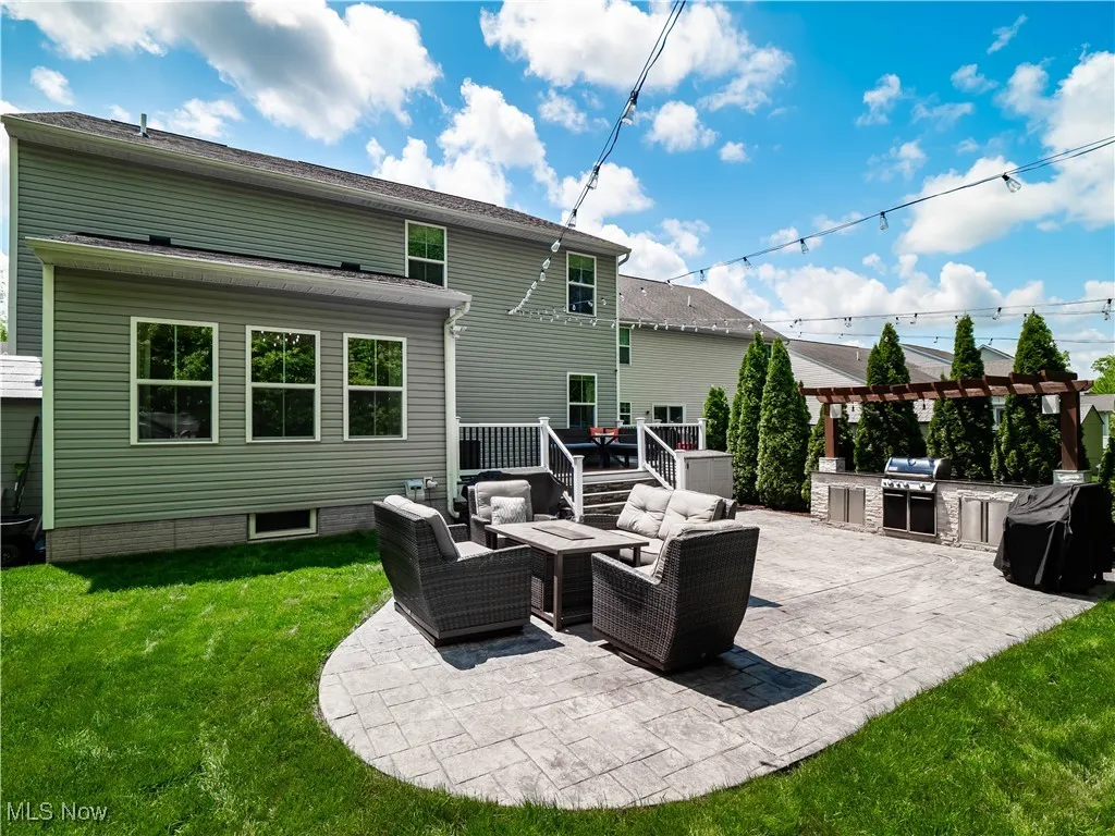 View of patio / terrace with an outdoor kitchen, an outdoor living space with a fire pit, a deck, and a pergola