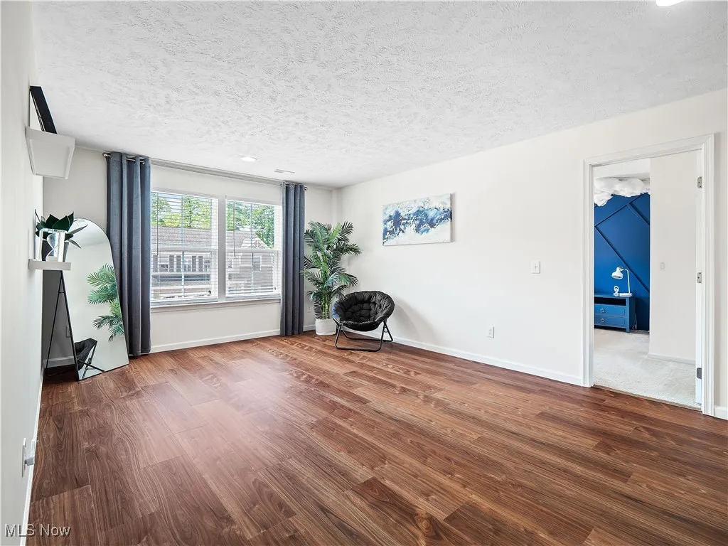 Living area with wood finished floors and a textured ceiling