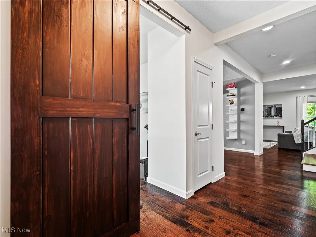 Entryway with a barn door, dark wood-style flooring, and recessed lighting