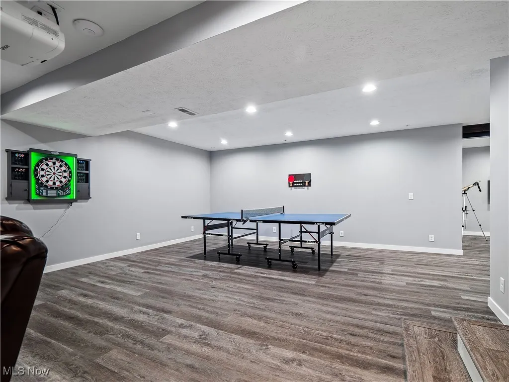 Recreation room with wood finished floors, recessed lighting, and a textured ceiling