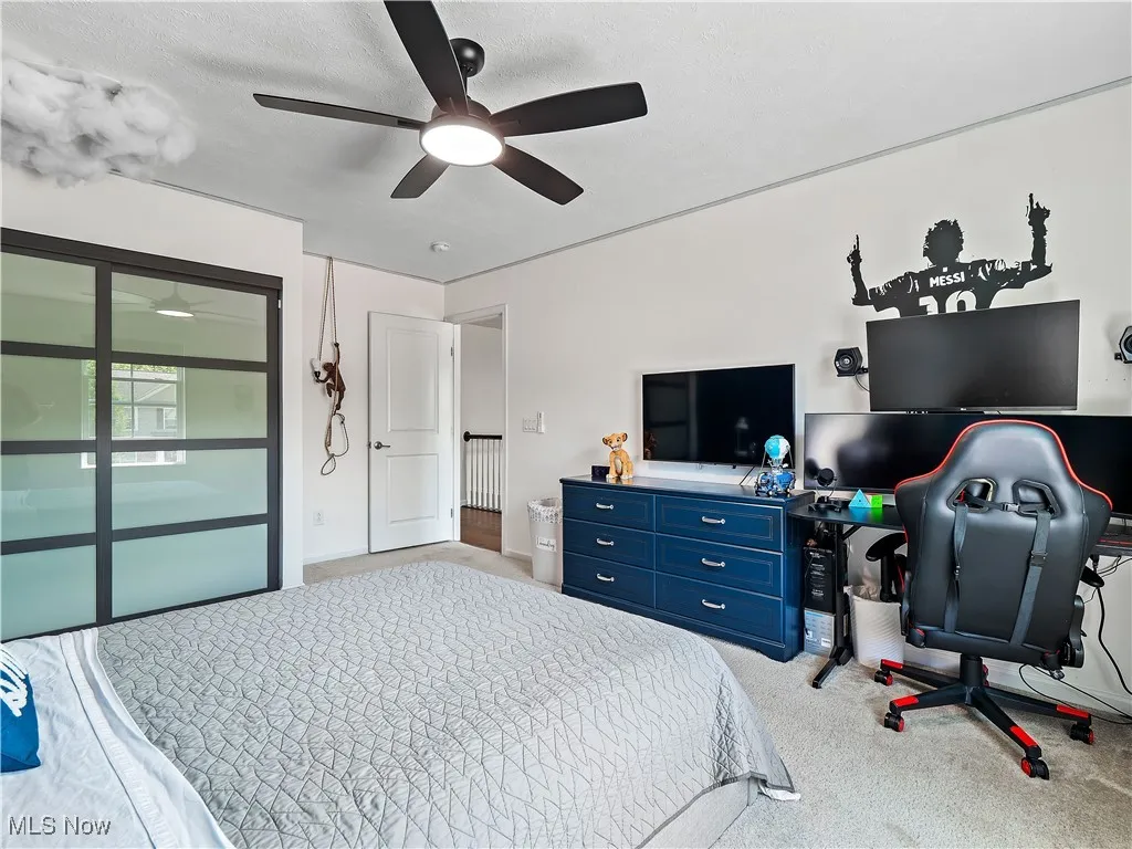 Carpeted bedroom featuring a ceiling fan