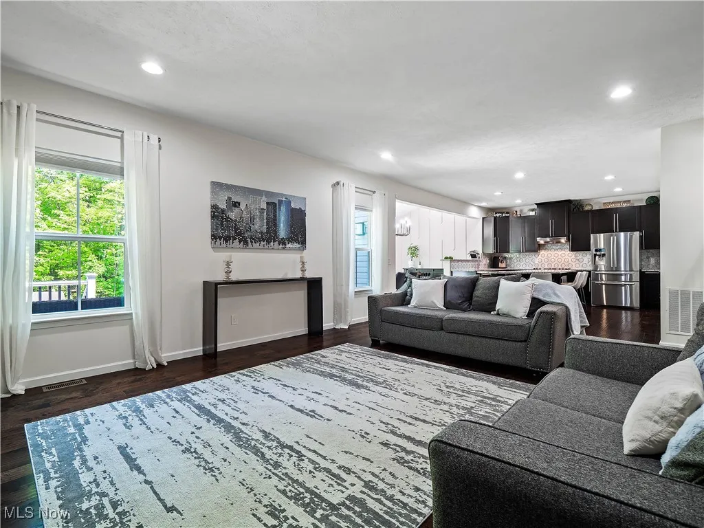Living room with recessed lighting and dark wood-type flooring