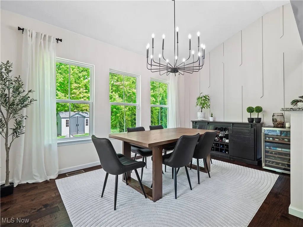 Dining area with beverage cooler, a chandelier, and wood finished floors