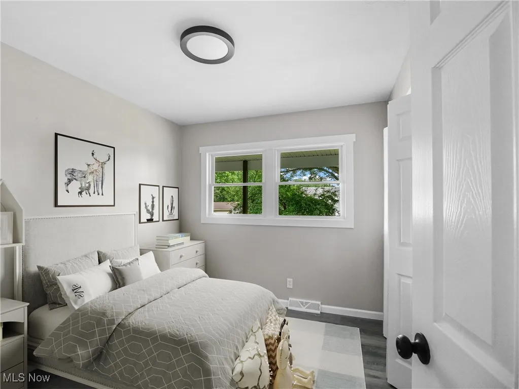 Bedroom with baseboards and dark wood-type flooring
